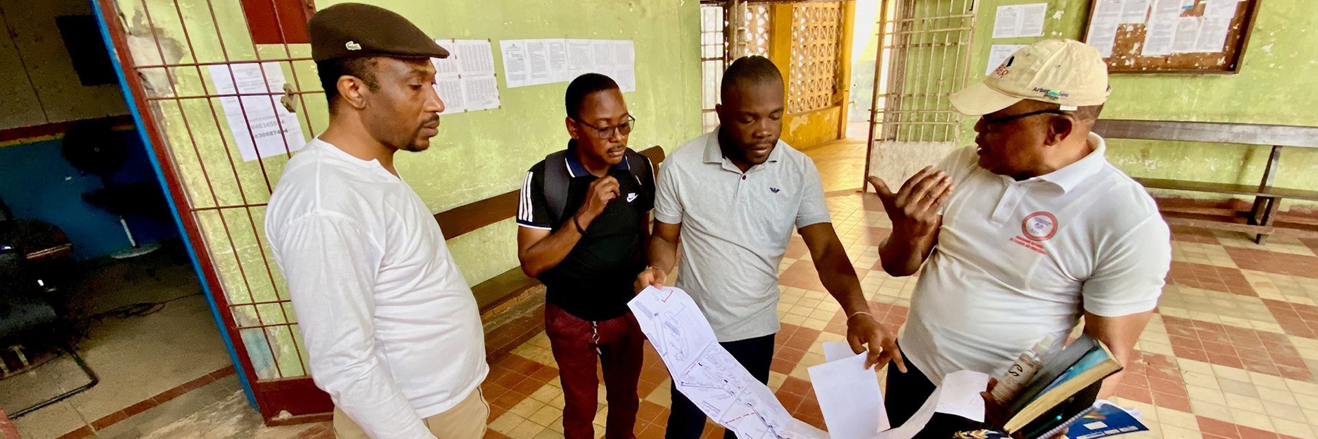 Four people looking at a big paper and discussing Four people looking at a big paper and discussing