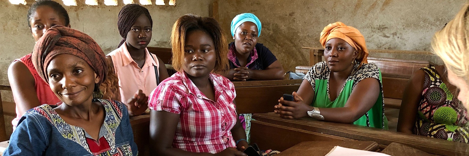 A person correcting and other ladies sitting next to it. A person correcting and other ladies sitting next to it.